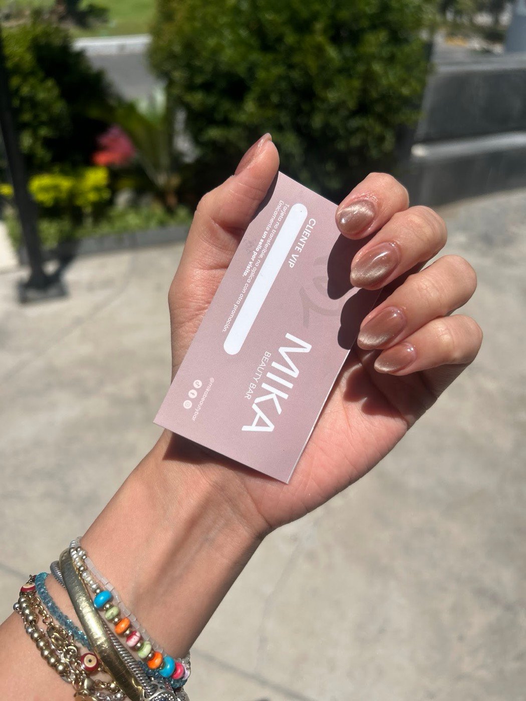 Tarjeta de Mika Beauty Bar en la mano de una clienta